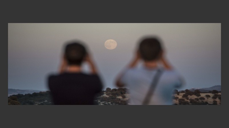 Dos aficionados a la astronomía disfrutan de la superluna en los Llanos de Espiel, España.
