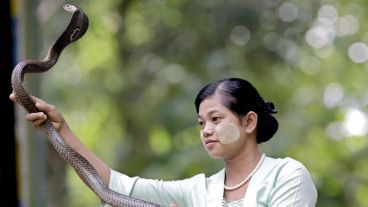Una mujer baila con una serpiente en el Zoo de la ciudad de Yangon en Birmania en el show de este sábado.