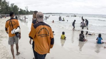 Miembros del equipo de rescate caminan una de las playas de la isla de Bintan, Indonesia; en busca de restos del avión desaparecido.