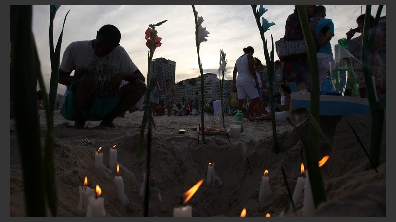 Velas encendidas para completar el ritual en el atardecer de Río este lunes 29 de diciembre.