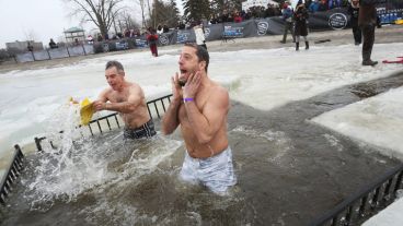 ¡Qué frío! Dos jóvenes se meten al agua con temperatura ambiente bajo cero.