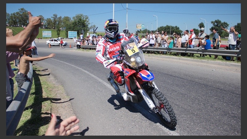 La gente saluda el paso de una moto en Pellegrini y Circunvalación.