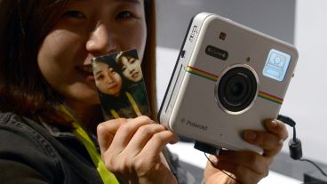¡Vuelve! Una mujer muestra una impresión de la cámara instantánea Polaroid Socialmatic.