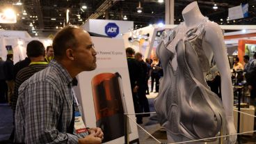Un visitante observa un traje futurístico en 3D de Autodesk.