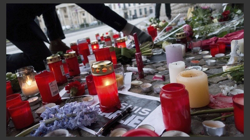 Un ciudadano deposita flores ante un altar en memoria de las víctimas del atentado en la embajada francesa en Berlín.