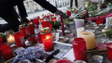Un ciudadano deposita flores ante un altar en memoria de las víctimas del atentado en la embajada francesa en Berlín.