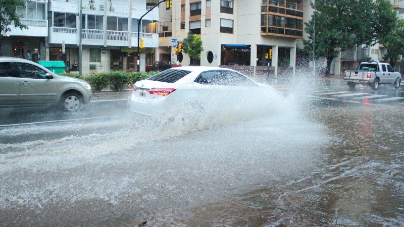 Mitad de avenida Pellegrini con agua frente a plaza López.