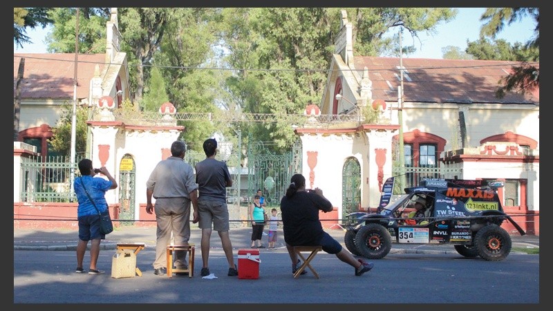 Una familia observa pasar un pequeño auto de competición.
