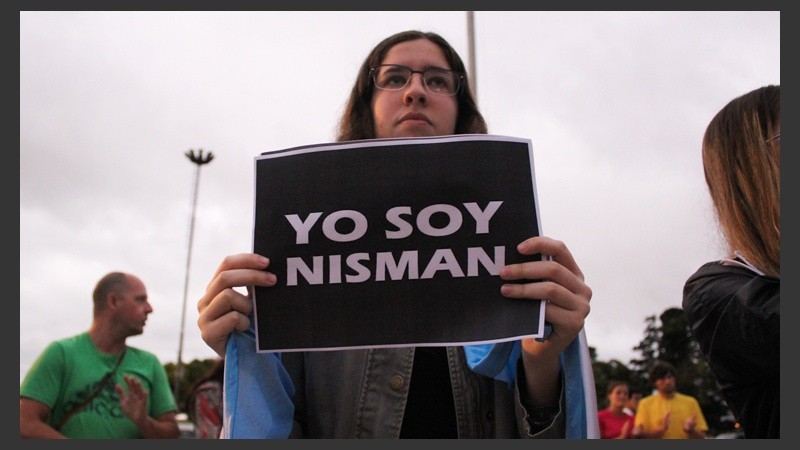 Una joven muestra un cartel con una leyenda imitando a 