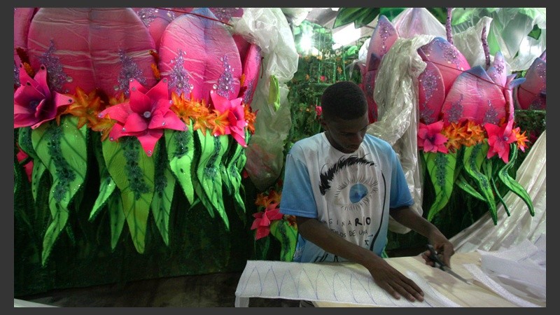 Otro joven recorta tela para armar los disfraces que se utilizarán en el sambódromo.
