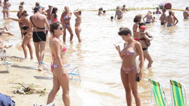 Dos chicas mojan sus pies a la orilla del río Paraná.