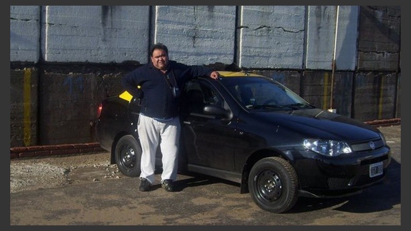 Hugo Camilo junto a su taxi, en el que fue baleado este jueves.