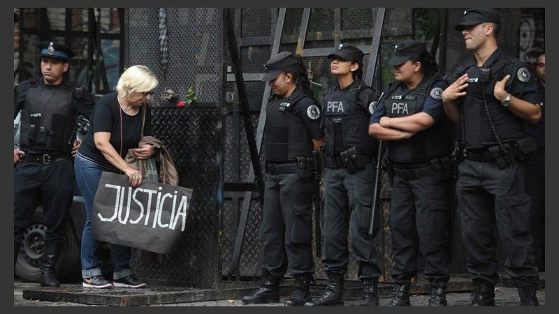 Una mujer coloca un cartel con la leyenda 