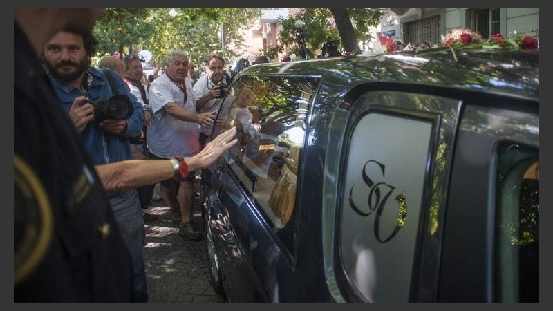 Una mano queriendo tocar el coche fúnebre.