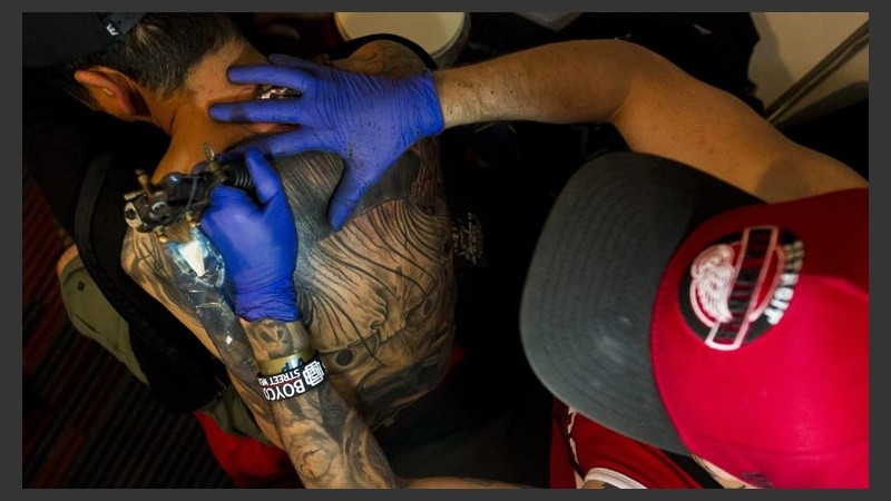Un tatuador en plena tarea.