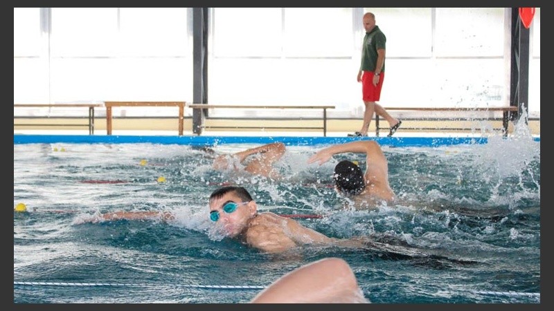 El profesor de nado vigila los movimientos de los chicos.
