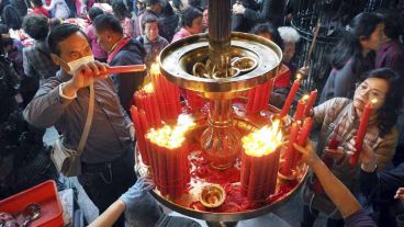 Varias personas prenden velas durante las celebraciones en Taipei (Taiwán).