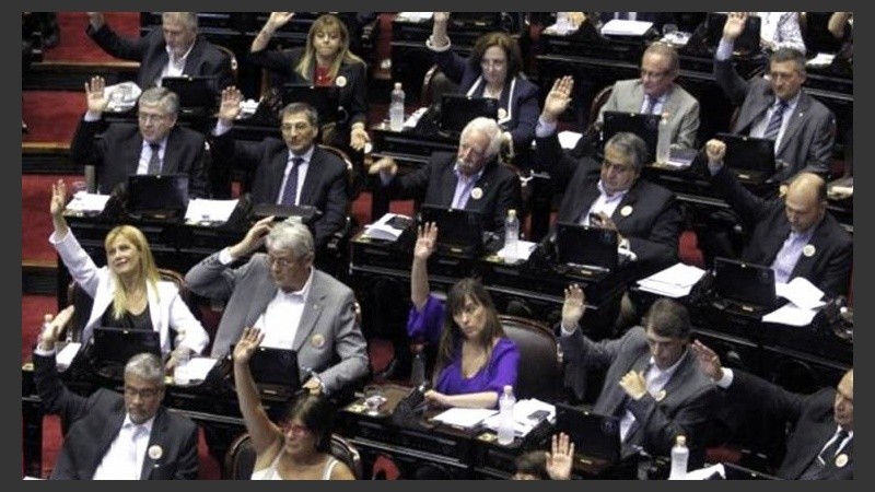 Arriba las manos para sancionar la ley.
