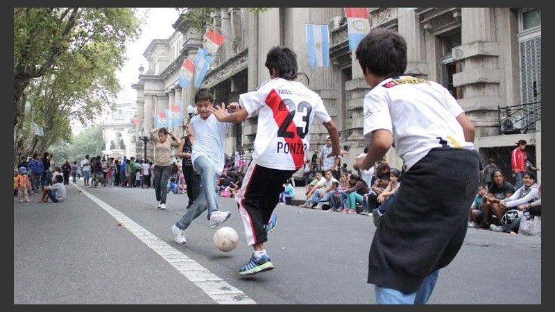 Varios pequeños juegan al fútbol sobre calle Santa Fe.