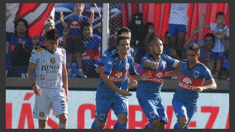 Luna celebra con sus compañeros y los hinchas festejan atrás. 