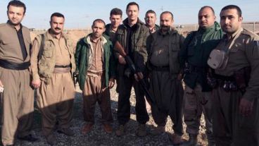 Mattioli en el centro portando una AK-47 junto a sus compañeros peshmerga