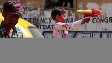 Un niño juega con una pistola de agua mientras disfruta del Festival Holi en Calcuta.