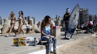 Un surfista israelí con una máscara de Guy Fawkes participa del concurso con motivo del "purim" en Ahdod.