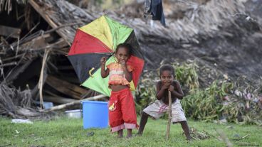 Dos niños juegan junto a las ruinas de su casa en la isla de Tanna en Vanuatu.