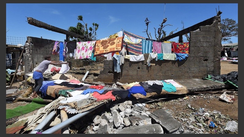 Una mujer coloca su ropa bajo el sol para secarla, tras el paso del ciclón Pam.