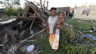Lana Silona sostiene en brazos a su hijo Costello junto a las ruinas de su casa en la isla de Tanna en Vanuatu.