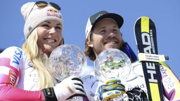 El esquiador noruego Kjetil Jansrud y la estadounidense Lindsey Vonn muestran sus respectivos trofeos de campeón en la clasificación general del supergigante.