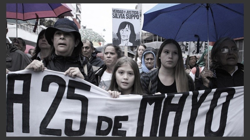 Una niña encabeza la marcha. Detrás, un cartel por Silvia Suppo, víctima del terrorismo de Estado. 