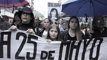 Una niña encabeza la marcha. Detrás, un cartel por Silvia Suppo, víctima del terrorismo de Estado.