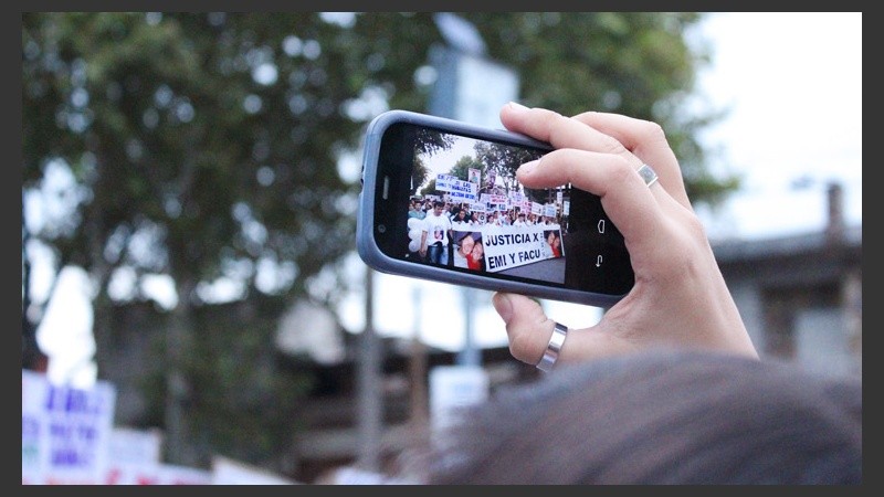Una mujer registra con su celular la movilización.