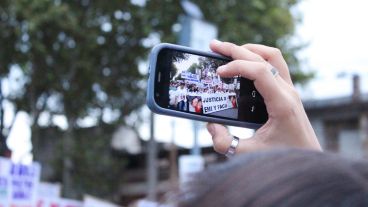 Una mujer registra con su celular la movilización.