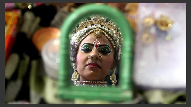 Una mujer mira a cámara a través de su espejo.