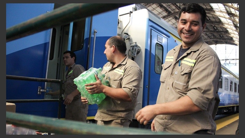 Unos hombres cargan botellas para el servicio de buffet.