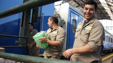 Unos hombres cargan botellas para el servicio de buffet.