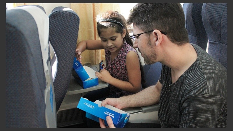 Una nena descubre unas masitas y un alfajor dentro de la caja.