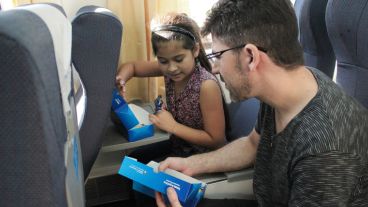 Una nena descubre unas masitas y un alfajor dentro de la caja.