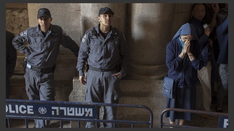  Una monja católica reza junto a policías fronterizos en la Iglesia de la Sagrada Sepultura en Jerusalén.