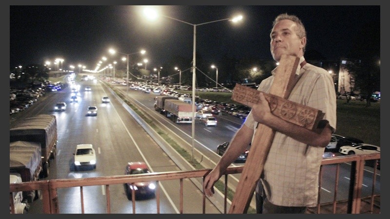 Un hombre carga una cruz en el inicio de la procesión.