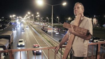 Un hombre carga una cruz en el inicio de la procesión.