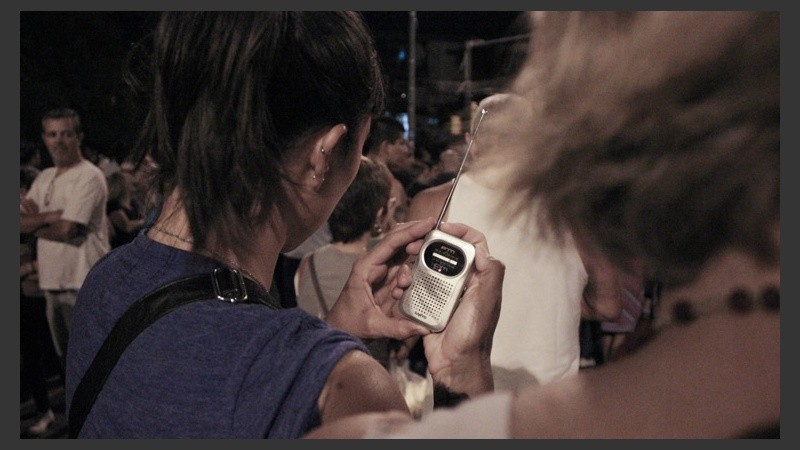 Una mujer trata de sintonizar Radio 2 para escuchar las oraciones en vivo del Padre Ignacio.