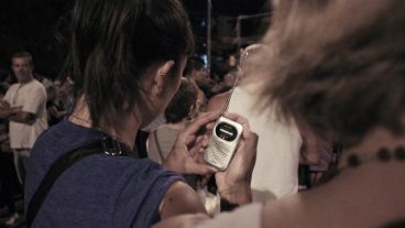 Una mujer trata de sintonizar Radio 2 para escuchar las oraciones en vivo del Padre Ignacio.