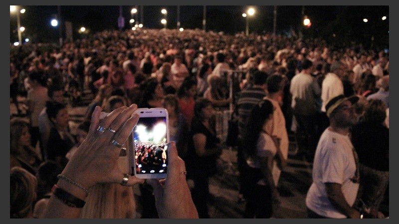 Una mujer saca una foto con celular para registrar la cantidad de gente.