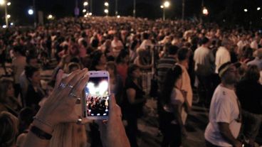 Una mujer saca una foto con celular para registrar la cantidad de gente.