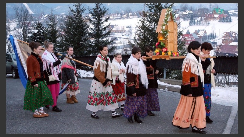 Personas vestidas en trajes tradicionales participan en una procesión de Pascuas en Polonia.
