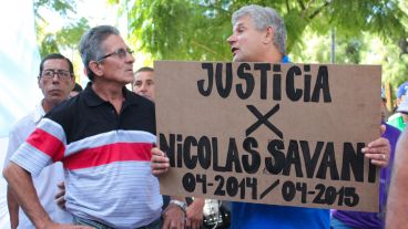Un hombre sostiene un cartel en pleno reclamo.