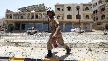 Un miliciano hutí intenta extinguir el fuego tras un supuesto bombardeo de la coalición árabe en Saná, Yemen.